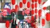 Seorang petugas valet mengenakan masker dan pelindung wajah, berdiri di depan etalase dengan dekorasi menyambut Tahun Baru Imlek di sebuah pusat perbelanjaan, di tengah pandemi COVID-19, di Jakarta, 10 Februari 2021. (REUTERS/Ajeng Dinar Ulfiana)
