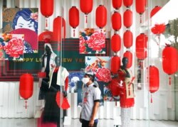 Seorang petugas parkir mengenakan masker dan pelindung wajah di tengah dekorasi Imlek di sebuah pusat perbelanjaan, di tengah pandemi COVID-19 di Jakarta, 10 Februari 2021. (REUTERS/Ajeng )