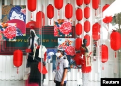 Seorang petugas parkir mengenakan masker dan pelindung wajah di tengah dekorasi Imlek di sebuah pusat perbelanjaan, di tengah pandemi COVID-19 di Jakarta, 10 Februari 2021. (REUTERS/Ajeng )