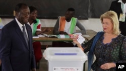 Le président de la Côte d'Ivoire, Alassane Ouattara, et son épouse, Dominique Ouattara, ont voté lors du référendum à Abidjan, en Côte d'Ivoire, 30 octobre 2016. 