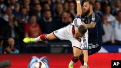 Le capitaine de l'équipe de l'Allemagne, Bastian Schweinsteiger, à gauche, dans l'action avec Steven Fletcher d'Ecosse, à droite, au cours de leur match de qualification de football à Hampden Park, Glasgow, Écosse, le lundi 7 septembre 2015. 