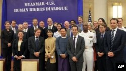 Myanmar opposition leader Aung San Suu Kyi, foreground third from left, and attendees pose for photos during the Myanmar-US Human Rights Dialogue in Naypyitaw, Myanmar, Wednesday, Oct. 17, 2012. (AP Photo/Khin Maung Win)