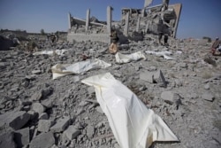 FILE - Bodies lie on the ground after being recovered from under the rubble of a Houthi detention center destroyed by Saudi-led airstrikes, in Dhamar province, southwestern Yemen, Sept. 1, 2019.