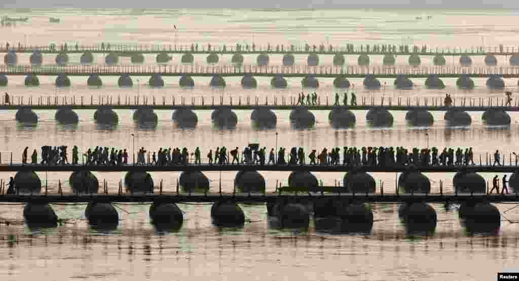 Hindu devotees cross pontoon bridges spanning the river Ganges during the first &quot;Shahi Snan&quot; (grand bath) at the ongoing &quot;Kumbh Mela&quot;, or Pitcher Festival, in the northern Indian city of Allahabad, January 14, 2013.
