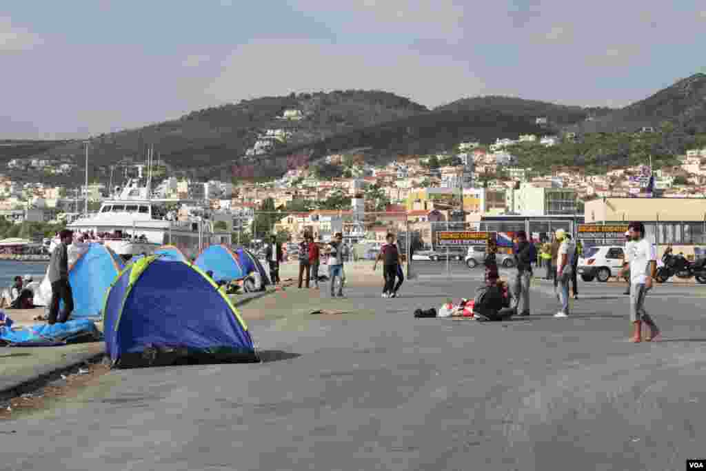 Many refugees from Afghanistan, Iraq and Syria who cannot afford the 48 euros for a boat to their next destination wait in tents, many hoping to find another way, at the port in Lesvos, Greece, Sept. 14, 2015. (Heather Murdock/VOA)