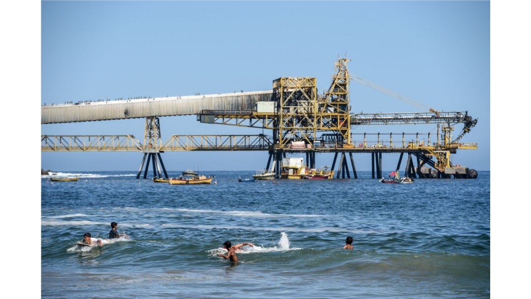 People cool off in the beach near the mining pipeline "Puerto Coloso" of the "Escondida" cooper mine in Antofagasta, Chile, Feb. 16, 2017.