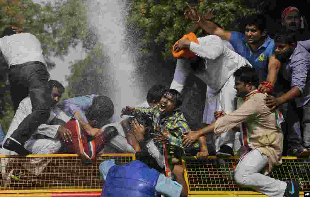 A supporter of the youth wing of India’s opposition Congress Party shouts slogans as police use water cannons to prevent demonstrators from marching towards the Indian Parliament during a protest in New Delhi, against a statement by India’s Human Resource Development Minister Smriti Irani on recent student protests.