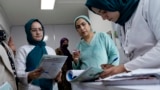 (FILE) This photograph taken on December 10, 2024 shows Dr. Najmussama Shefajo along with other female midwives and nurses, checking the documents of pregnant women at her private hospital in Kabul.