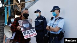 Pro-democracy supporters protest to urge for the release of 12 Hong Kong activists arrested as they reportedly sailed to Taiwan for political asylum and citizen journalist Zhang Zhan outside China's Liaison Office, in Hong Kong, Dec. 28, 2020.