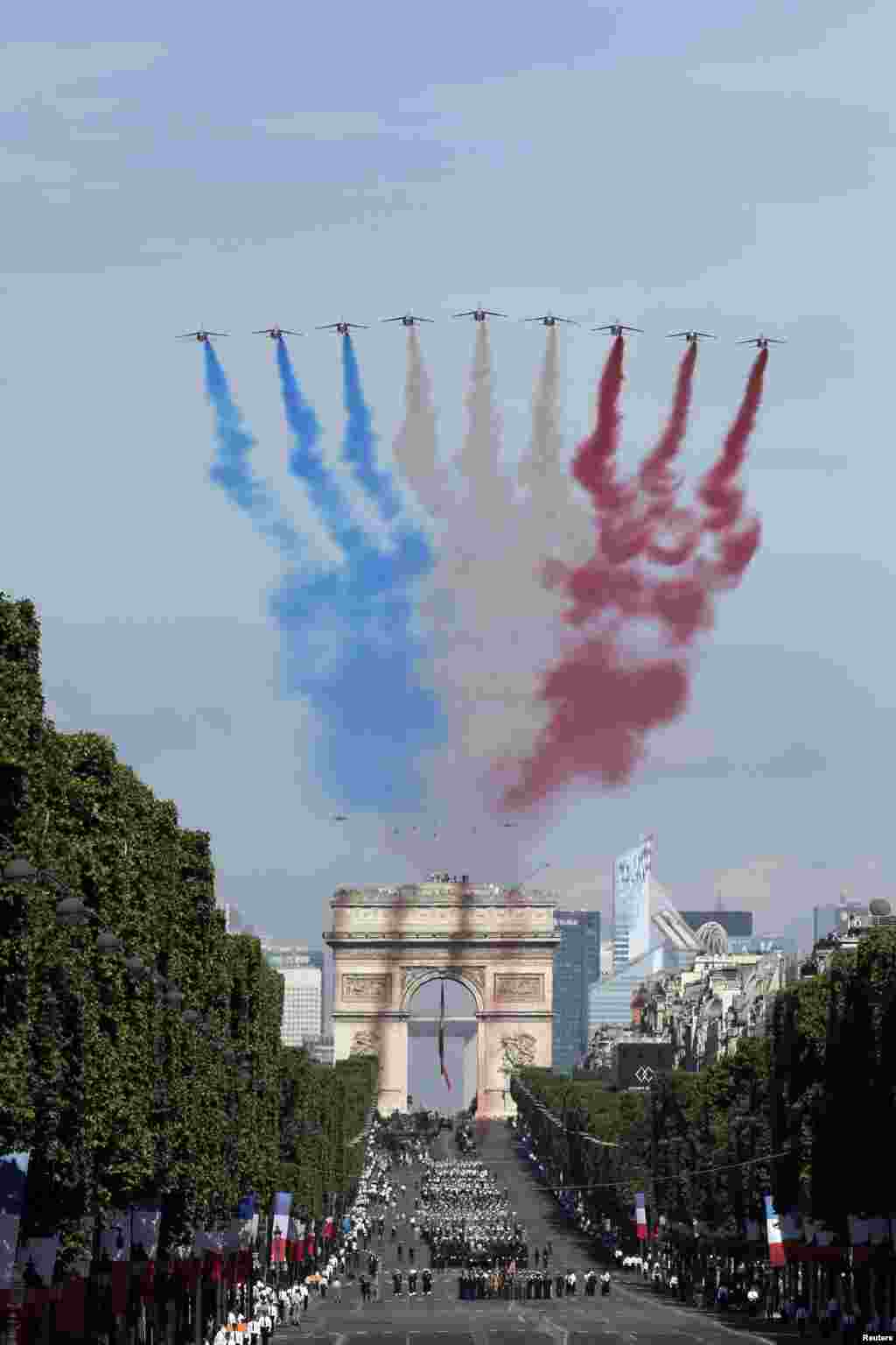 法国国庆节游行，法国空军的巡逻兵飞行表演队飞过巴黎凯旋门和香榭丽舍大道上空，喷出法国国旗颜色的烟。（2017年7月14日）。 7月14号也被称为&ldquo;巴士底日&rdquo;。1789年的这一天，反叛者们冲入巴黎的巴士底监狱，这一事件标志着法国大革命的开始。
