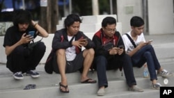 People look at their smartphones as they play "Pokemon Go" in Jakarta, Indonesia. Indonesian authorities banned the playing of "Pokemon Go" from the presidential palace on Wednesday, July 20, 2016. (AP Photo/Tatan Syuflana)