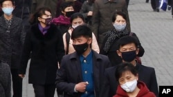 People wear face mask amid the concern over the spread of the coronavirus in Pyongyang, North Korea, Wednesday, April, 1, 2020. 