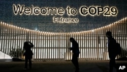 People walk outside the venue for the COP29 U.N. Climate Summit, in Baku, Azerbaijan, Nov. 11, 2024. 