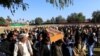 FILE - Afghan men carry the coffin of journalist Malalai Maiwand, who was shot and killed by unknown gunmen in Jalalabad, Afghanistan, Dec. 10, 2020.