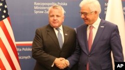 U.S. deputy secretary of state, John Sullivan, right, shakes hands with Polish Foreign Minister Jacek Czaputowicz in Warsaw, Poland, Wednesday, Dec. 19, 2018.