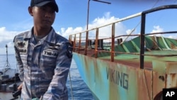 FILE - Indonesian navy personnel stand guard on an Indonesian navy ship anchored next to illegal fishing vessel Viking which was seized by Indonesia’s Navy before its sinking in the waters off Pangandaran, West Java, Indonesia, March 14, 2016. 