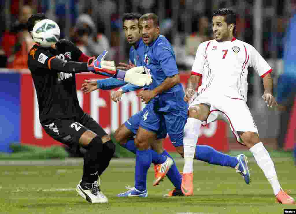 Kuwait's goalkeeper Nawaf Al Khaldi (L) attempts to save the ball against UAE's Ali Ahmed al-Hajri (R) during their Gulf Cup Tournament semi-final soccer match in Isa Town, Bahrain, January 15, 2013. 