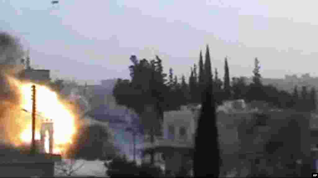 This image from amateur video released by Syrian Media Centre purports to show an explosion as a tank fires a shell in Idlib, Syria, March 13, 2012. (AP/Syrian Media Centre)