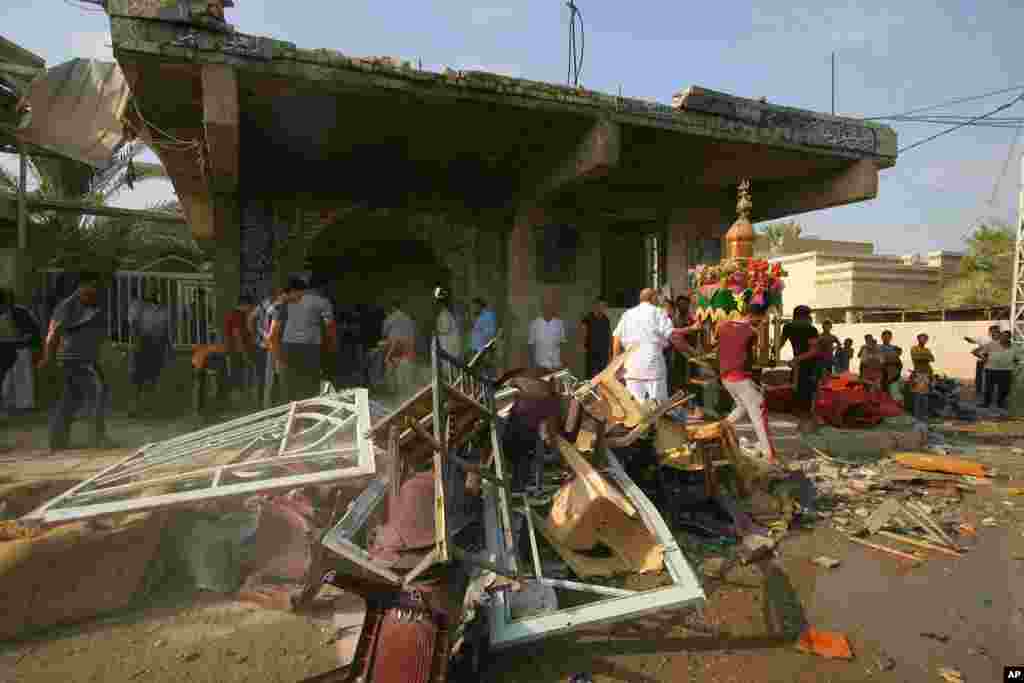 Iraqis assess the damage from a bomb attack at a mosque in Hilla, about 95 kilometers south of Baghdad, Aug. 25, 2014.