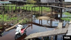 Bridges above roads link houses to cope with regular flooding, Kalanis village, South Barito, Central Kalimantan, Indonesia. (B. Hope/VOA)