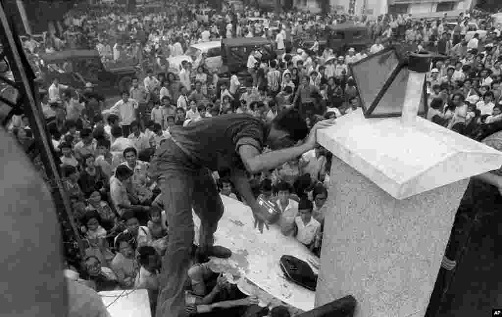 Đám đông hỗn loạn leo qua bức tường của Đại sứ quán Mỹ ở Sài Gòn,&nbsp;cố gắng để đến được những chiếc trực thăng di tản trong lúc người Mỹ cuối cùng rời khỏi Việt Nam. &nbsp;