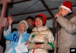 Russian human rights activist Lyudmila Alexeyeva, dressed as Snegurochka, Russian Snow Maiden, left, environmental activist Yevgenia Chirikova, center, and prominent rights activist Lev Ponomaryov speak during a rally in central Moscow, Dec. 31, 2010.