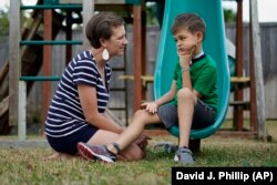 Rachel Scott, left, talks with her son, Braden, in Tomball, Texas on Friday, March 29, 2019. “Everyone is desperate for some magical thing” to cure the kids, said Rachel. Braden developed acute flaccid myelitis, or AFM, in 2016.