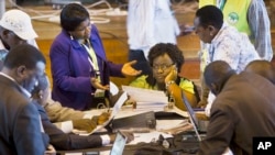 Official representatives of the various political parties and electoral workers discuss while reviewing newly received results, at the National Tallying Center in Nairobi, Kenya, March 6, 2013.