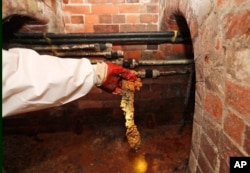 Thames Water field operation manager Natalie Stearn holds a piece of the Fatberg in an 1852-built sewer at Westminster in London, Sept. 25, 2017.