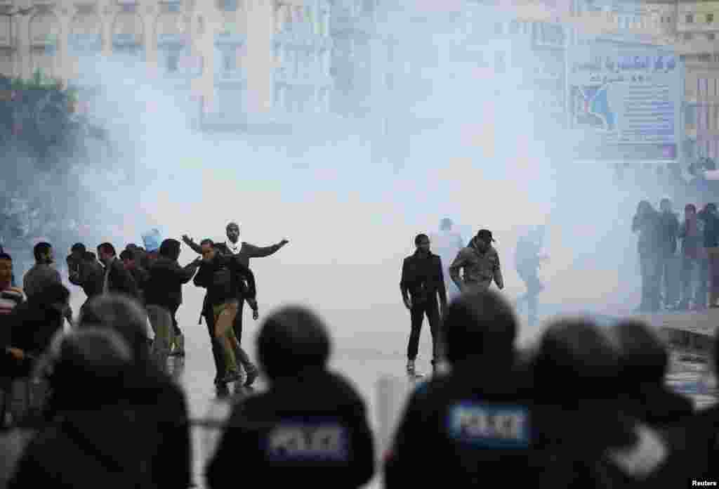 Riot police use tear gas to disperse protesters opposing Egyptian President Mohamed Morsi in Alexandria, Egypt, December 21, 2012. 