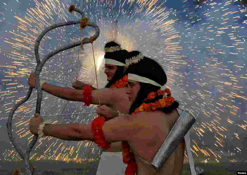 Artists dressed as Hindu gods Rama and Laxman act as fireworks explode during Vijaya Dashmi, or Dussehra festival celebrations in Chandigarh, India, Sept. 30, 2017.