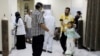 In this May 12, 2020 photo, Yemeni medical workers wearing masks and protective gear talk to patients at hospital in Aden, Yemen.