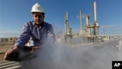 FILE - In this photo from February 2011, an employee works at an oil refinery in eastern Libya. 