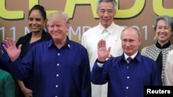Le président américain Donald Trump, à droite, et le président russe Vladimir Poutine prennent part à une photo au sommet de l'Apec à Danang, Vietnam, 10 novembre 2017.