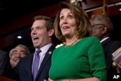 House Minority Leader Nancy Pelosi of Calif. (right) accompanied by Rep. G. K. Butterfield, D-N.C. (left) and Rep. Eric Swalwell, D-Calif. (second from left) as they joke while speaking at a news conference on Capitol Hill in Washington, March 24, 2017.