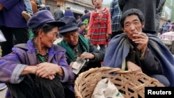 Yi ethnic minority women count money at a local market in Butuo County, Sichuan province, China, July 18, 2017. 