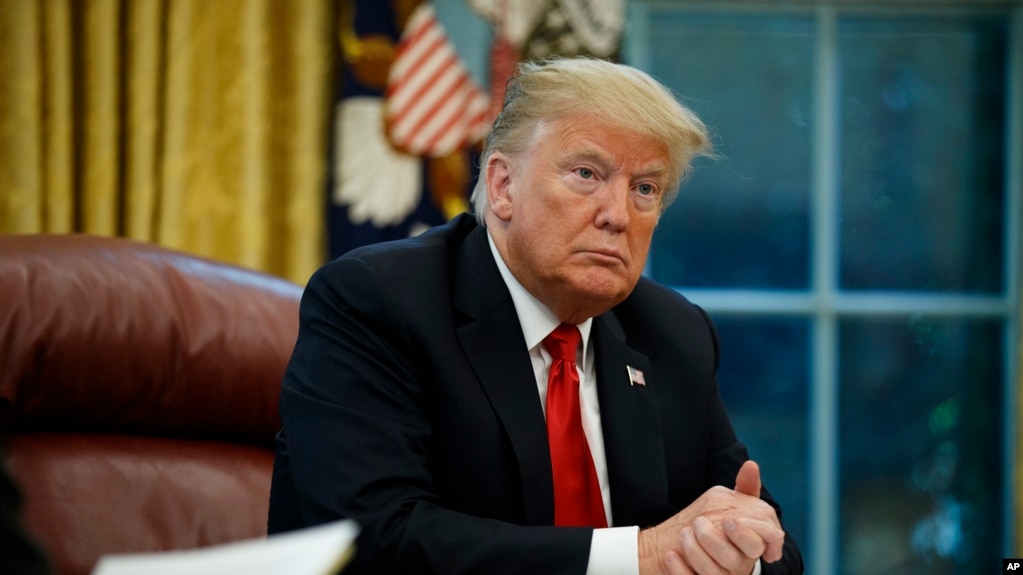 FILE - President Donald Trump listens to a question during an interview in the Oval Office of the White House, in Washington, Oct. 16, 2018.