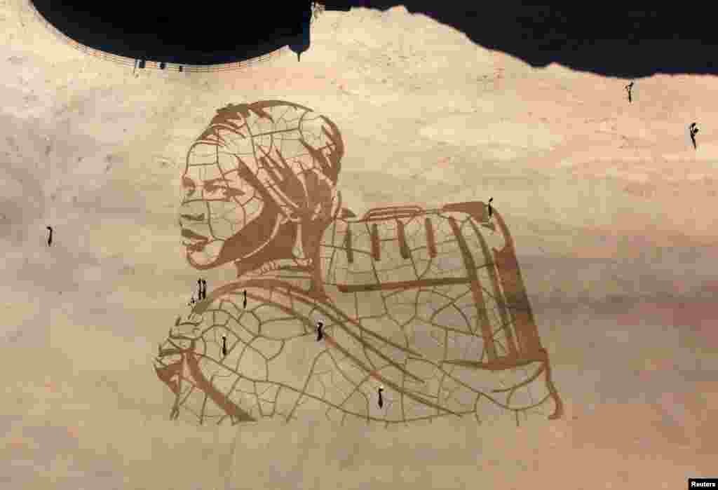 A giant sand portrait, &quot;WaterAid and Sand In Your Eye,&quot; can be seen on Whitby Beach in Britain, March 15, 2021.