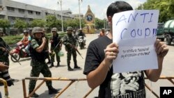 Seorang pelajar berdiri di depan sekelompok tentara dalam sebuah protes di dekat Monumen Demokrasi Bangkok, Thailand 23/5/2014. 