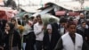 FILE - Iranian people walk at a flower market, ahead of Nowruz, the Persian new year, in Tehran, Iran, March 17, 2024. (Majid Asgaripour/WANA via Reuters) 