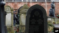 FILE - People visit the Warsaw Jewish Cemetery on Okopowa Street in Warsaw, Poland, Dec. 22, 2017.
