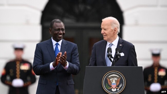 FILE— US President Joe Biden (R) speaks as Kenyan President William Ruto (L) applauds during an official arrival ceremony on the South Lawn of the White House in Washington, DC, on May 23, 2024.