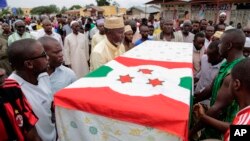 Para pria mengusung peti jenazah pemimpin oposisi Zedi Feruzi dalam pemakamannya di Bujumbura, Burundi (24/5). (AP Photo/Gildas Ngingo)
