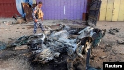 An Iraqi policeman inspects the site of a car bomb attack in Kirkuk, north of Baghdad, July 11, 2013.