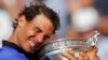 Spain's Rafael Nadal holds the trophy as he celebrates winning his tenth French Open title against Switzerland's Stan Wawrinka, during their men's final match of the French Open tennis tournament at Roland Garros stadium, in Paris, June 11, 2017.