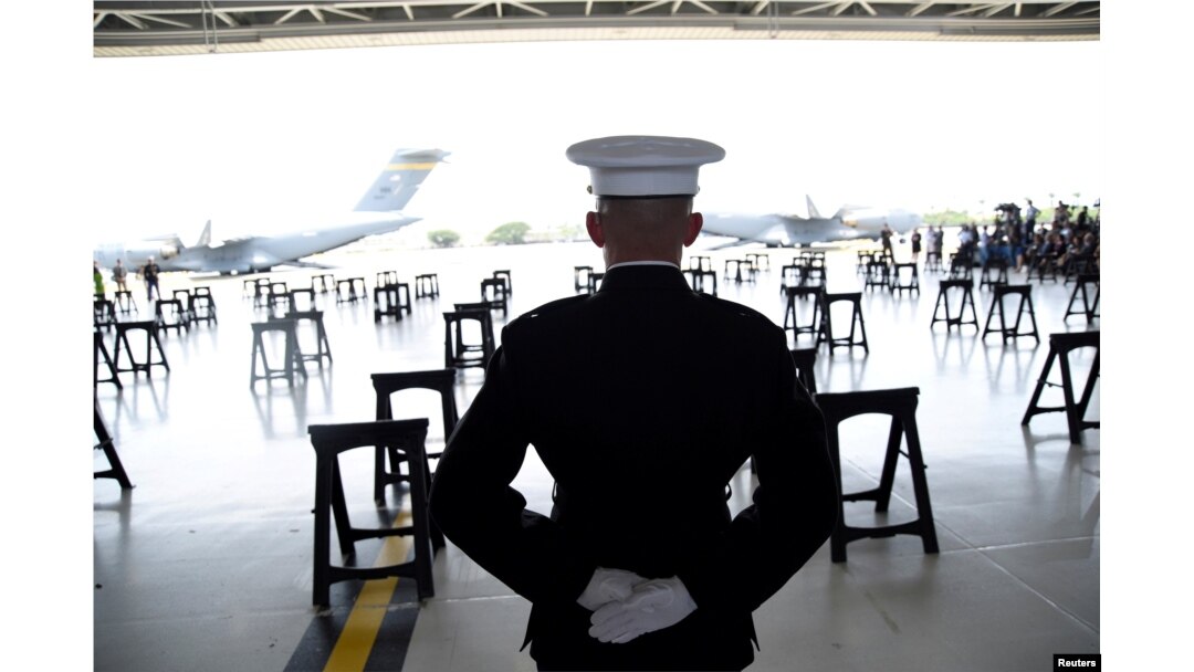 A U.S. Marine stands at attention as caskets containing the remains of American servicemen from the Korean War handed over by North Korea arrive at Joint Base Pearl Harbor-Hickam in Honolulu, Hawaii, U.S., Aug. 1, 2018.