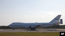 The Shuttle Carrier Aircraft arrives at the Shuttle Landing Facility at NASA's Kennedy Space Center in Florida at 5:35 p.m. EDT to prepare for space shuttle Discovery's ferry flight to Virginia.