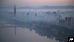 Dawn breaks over Pyongyang, North Korea, as buildings poke through the midst and the Juche Tower, left, stands by the Taedong riverbank, Oct. 13, 2015.