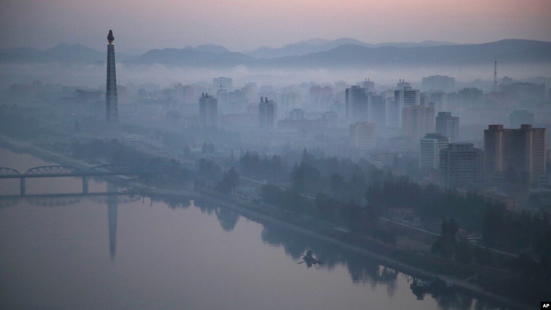 Dawn breaks over Pyongyang, North Korea, as buildings poke through the midst and the Juche Tower, left, stands by the Taedong riverbank, Oct. 13, 2015.