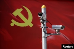 资料照：以中共党旗为背景的监测摄像头